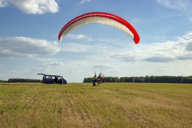 Moto yamaç paraşütü yerde ve havada.