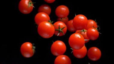 Siyah arka plan üzerinde Domates objektif yaklaşım. Yavaş çekim