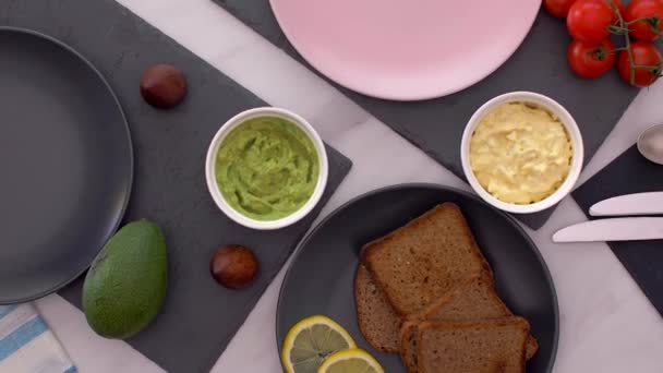 Desayuno saludable con sándwich de aguacate y ensalada de huevo vista superior — Vídeo de stock