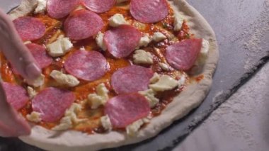 Şef pizzaya salam koyar. Yavaş çekim