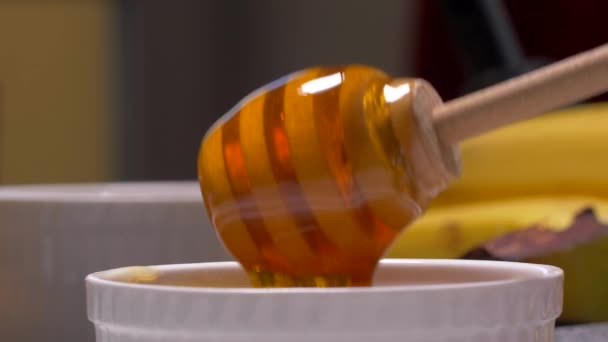 Zdravý organický med. Hustý med odkapávající z dřevěné medové lžíce. — Stock video