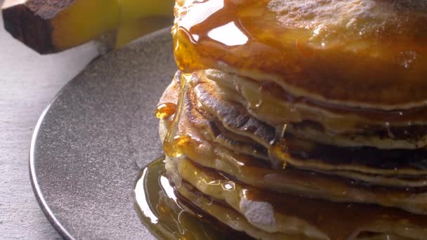 Gieten van Amerikaanse pannenkoeken met honing. Slow Motion — Stockvideo