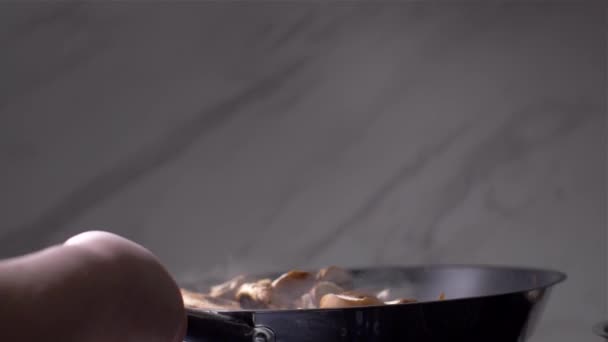 Кухар кидає гриби на сковороду — стокове відео