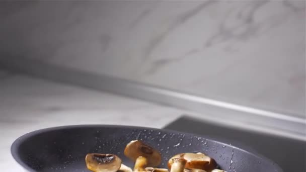 Szef kuchni wyrzuca grzyby na patelni — Wideo stockowe
