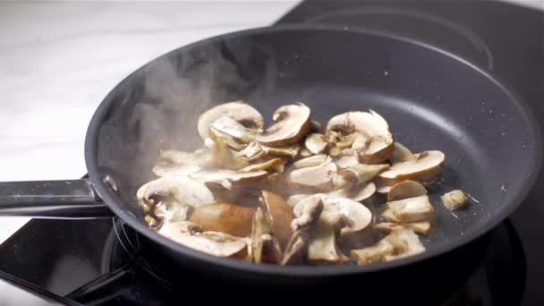 Шеф-повар бросает грибы в сковороду — стоковое видео
