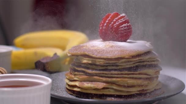 Amerikanische Pfannkuchen mit Puderzucker bestreuen. Zeitlupe — Stockvideo