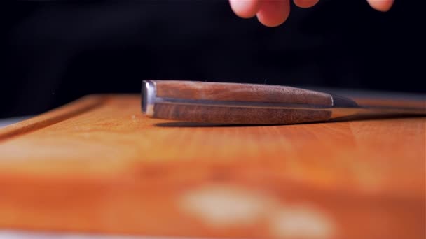 Kocken plockar upp kniven från skärbrädet. Slow motion — Stockvideo