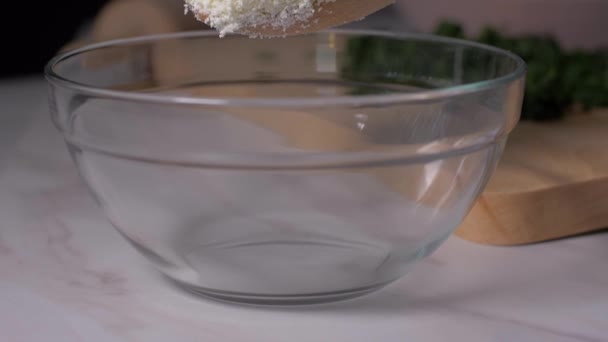 Добавление сыра в миску с деревянной ложкой — стоковое видео