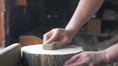Marangoz masaüstünde zımpara ile ahşap tahta parlatır.