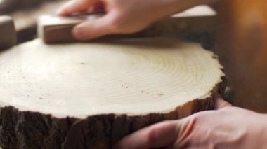 Marangoz masaüstünde zımpara ile ahşap tahta parlatır.