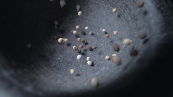 Pour black and white pepper into a mortar. Slow motion — Stock Video