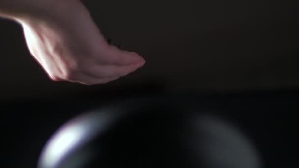 Жіноча рука наливає чорно-білий перець у міномет. Повільний рух — стокове відео