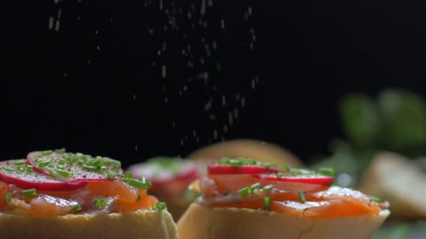 Polvilhe um sanduíche com salmão com pimenta. Movimento lento — Vídeo de Stock
