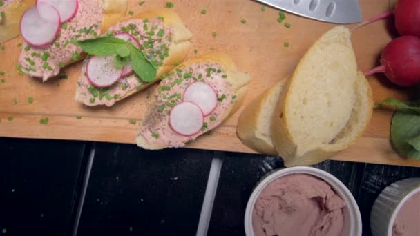 Deliciosos sándwiches con una pasta sobre una tabla de madera — Vídeo de stock