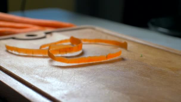 Carrot cuttings fall on a wooden board. slow motion — Stock Video