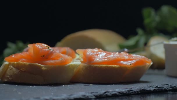 Colocar rábano en un sándwich de salmón. Movimiento lento — Vídeos de Stock