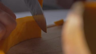 Tahta bir tahtaüzerinde bıçakla balkabağı kesin.