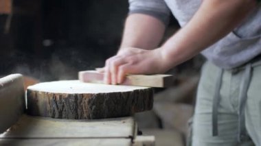 Marangoz masaüstünde zımpara ile ahşap tahta parlatır.