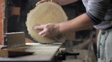 Marangoz masaüstünde zımpara ile ahşap tahta parlatır.