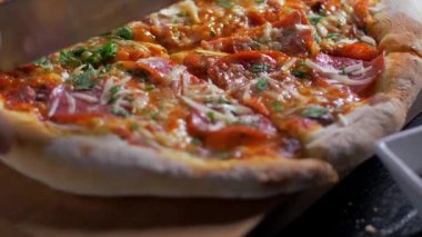Şef pizzacı ahşap masada bıçak ile pizza kesme. 