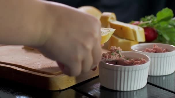 Sandwiches mit einer Paste auf einem Holzbrett zubereiten. Zeitlupe — Stockvideo