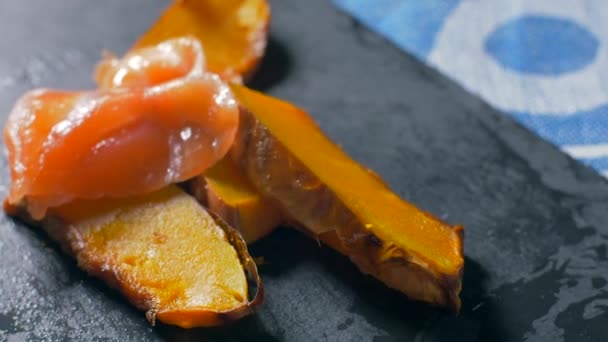 Lachs auf einen gut gebackenen Kürbis legen. Zeitlupe — Stockvideo