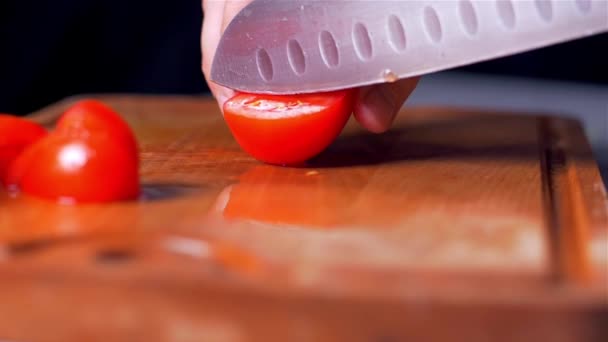 Couper les tomates sur une planche en bois pour la coupe. ralenti — Video