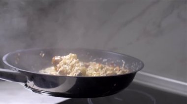 Şef bir tavada mantar ile risotto atar. yavaş çekim