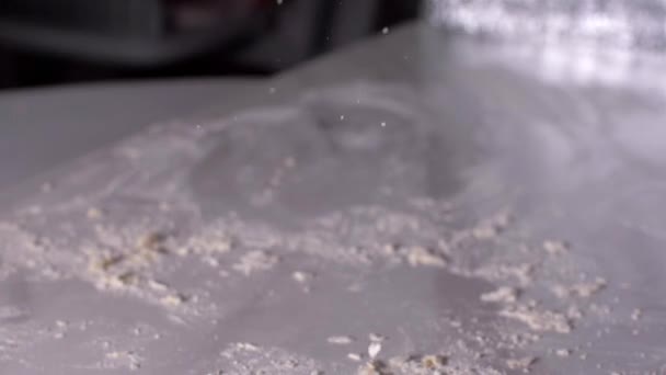 Пекарь смешивает тесто в муке на столе, замедленная съемка — стоковое видео