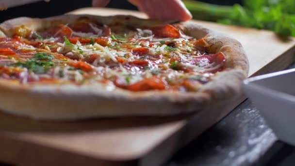 Cocinero cortando pizza con cuchillo en mesa de madera en pizzería . — Vídeos de Stock