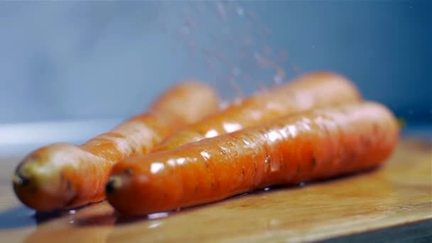 Мытье свежей моркови на деревянной доске в замедленной съемке — стоковое видео