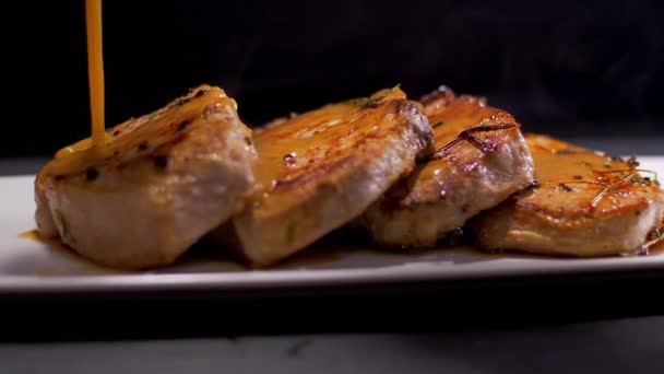 Sabrosos filetes de cerdo. Verter con salsa asada — Vídeo de stock