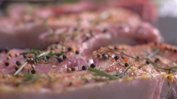 Посыпание сырой свиной отбивной с костью со смесью специй — стоковое видео