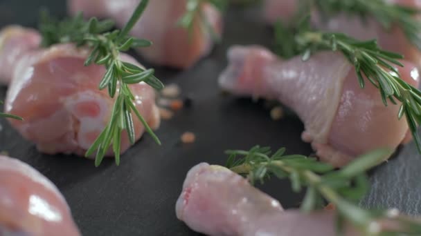 Rå kycklingben smaksatt med salt peppar och rosmarin — Stockvideo