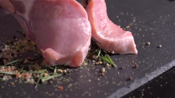 Côtelettes de porc crues trébuchantes avec l'os dans le mélange d'épices — Video