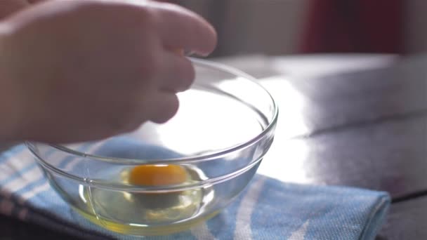 Breaking eggs into a glass bowl — Stock Video