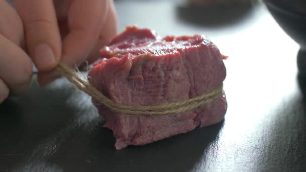 Beef fillet slices wrapped being secure with  twine — Stock Video