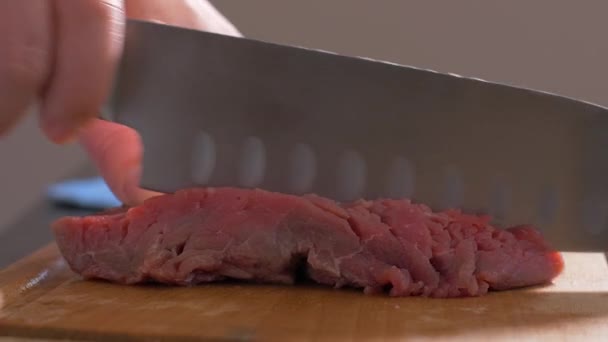 Cutting a filet mignon with a knife on a wooden board — Stock Video