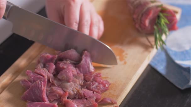 Разрезание филе миньон с ножом на деревянной доске — стоковое видео
