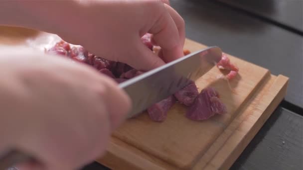 Snijden van een filet Mignon met een mes op een houten plank — Stockvideo