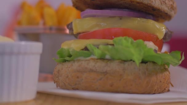 Saftige amerikanische Burger mit knusprigen Pommes frites. Zeitlupe — Stockvideo
