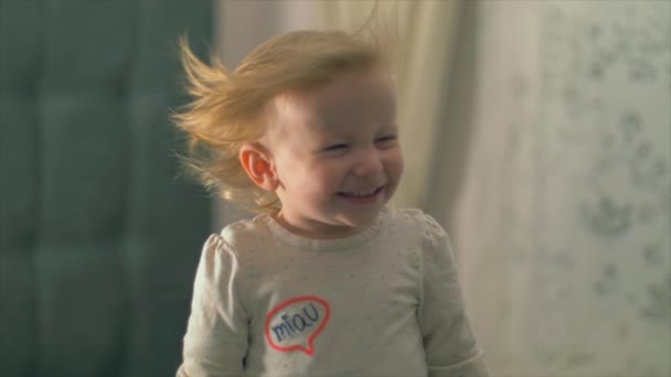 Söt baby flicka med hår utvecklas i vinden. Slow motion — Stockvideo