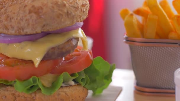Hamburguesa americana jugosa con papas fritas crujientes. Movimiento lento — Vídeos de Stock