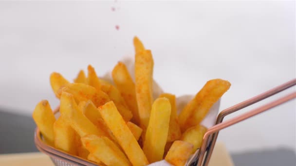 Delicious crispy fried potatoes. Sprinkle with red pepper. Slow motion — Stock Video