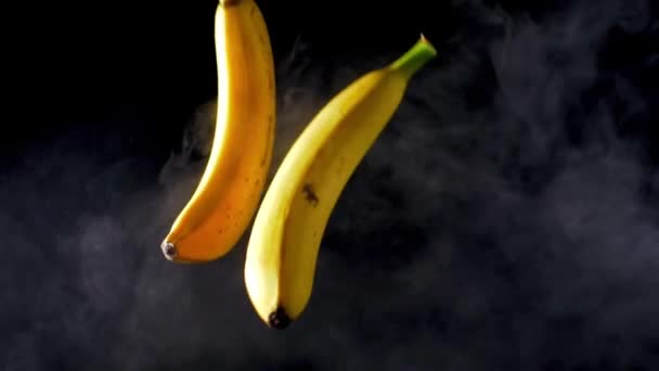 Bananenwerfen. geräuchertem schwarzen Hintergrund. Zeitlupe — Stockvideo