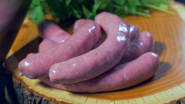 Raw sausages on a wooden board — Stock Video