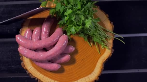 Raw sausages on a wooden board — Stock Video