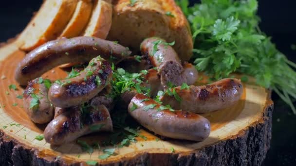 Сочные жареные колбаски на деревянной доске — стоковое видео