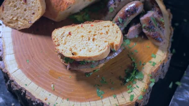 Un delicioso sándwich con salchichas en una tabla de madera — Vídeo de stock