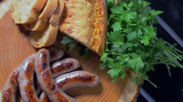 Saucisses grillées juteuses sur une planche de bois — Video